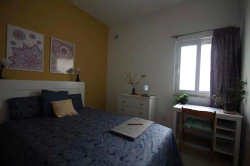 a bedroom with a bed and a desk and a window at HomeStay @ Viewpoint St Julians in St. Julianʼs