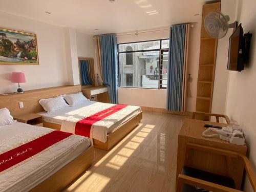 een hotelkamer met 2 bedden en een raam bij Grand Budapest Hotel in Cat Ba