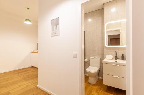 a white bathroom with a toilet and a sink at D&S - Crocodile House S. Bento Apartments in Porto