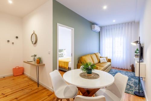 uma sala de estar com uma mesa e cadeiras e um sofá em D&S - Crocodile House S. Bento Apartments no Porto