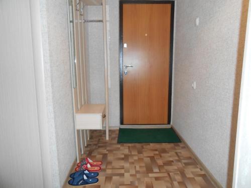 un pasillo con una puerta y unos zapatos en el suelo en Уютная однокомнатная квартира, en Almaty