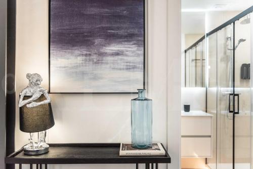 La salle de bains est pourvue d'une table et d'un vase. dans l'établissement Contemporary luxe duplex in the heart of Malaga by REMS, à Malaga