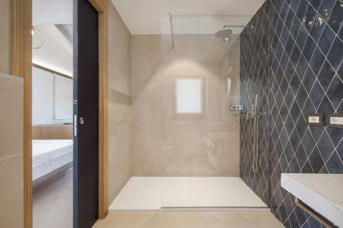 un bagno con doccia con porta in vetro di Villa Divina22-APT Unica-Con piscina e vista lago a Castelletto di Brenzone