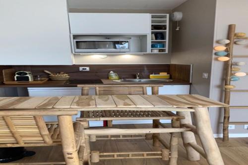 uma cozinha com uma mesa de madeira e um lavatório em Ma cabane de plage em Fécamp
