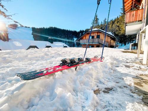 a swing in a pile of snow in front of a house at Sunshine Apartments Golte C1 in Mozirje