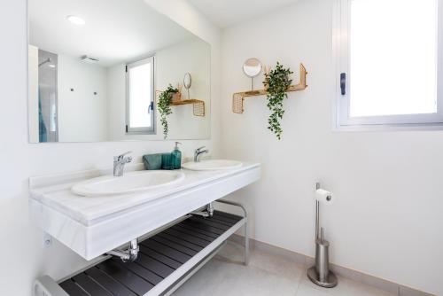 a white bathroom with two sinks and a mirror at Bahia de Torrequebrada - 2 Bedroom Apartment with Seaview in Benalmádena