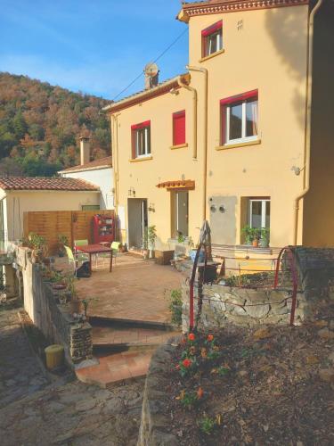 une maison avec une terrasse en face de celle-ci dans l'établissement Maison Do Mi Sol, à Reynès