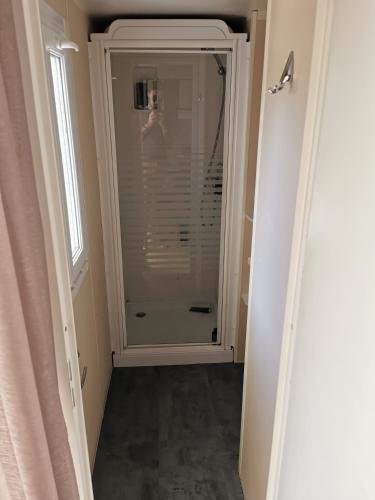 La salle de bains est pourvue d'une douche à l'italienne à côté d'une fenêtre. dans l'établissement Mobil-Home en camping****, à Vic-la-Gardiole