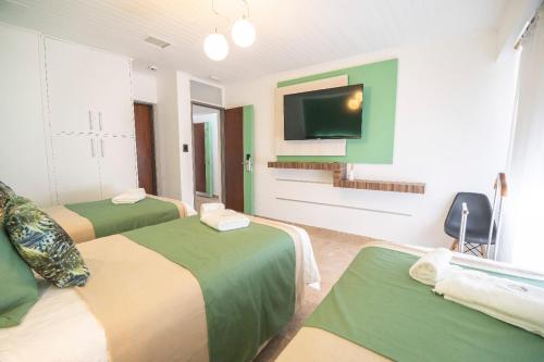 a hotel room with two beds and a flat screen tv at PUNTO SUR HOTEL BOUTIQUE in Malargüe