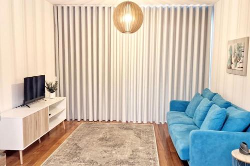 a living room with a blue couch and a television at Ocean Pearl Apartment K in Funchal