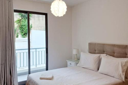 um quarto com uma cama grande e uma varanda em Ocean Pearl Apartment K em Funchal