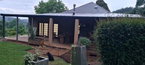 a house with a black roof and a yard at A2B Eco Farm Guest House in Byrne
