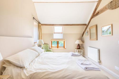 ein Schlafzimmer mit einem großen weißen Bett in einem Zimmer in der Unterkunft The Granary at Hawkhurst in Craven Arms