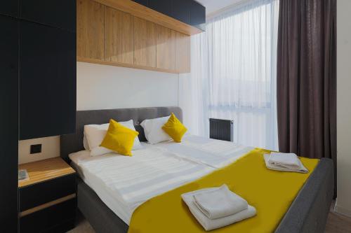 a bedroom with a large bed with yellow pillows at Welcome Republic Square Apartments in Yerevan