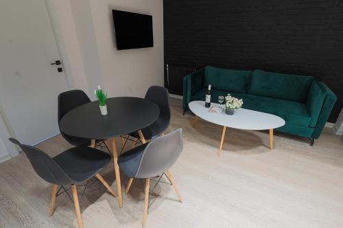 a living room with two tables and a green couch at Welcome Republic Square Apartments in Yerevan