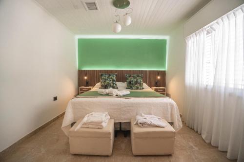 sypialnia z dużym łóżkiem z 2 otomanami w obiekcie PUNTO SUR HOTEL BOUTIQUE w mieście Malargüe