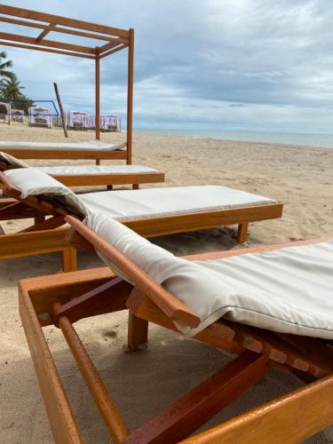 a group of wooden beds on the beach at Pousada Do Vozinho in Touros