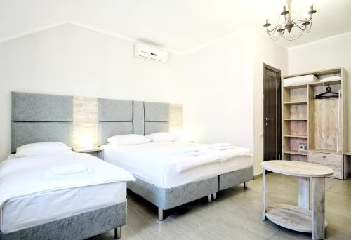1 dormitorio con 2 camas y mesa. en Hotel Rodos, en Adler