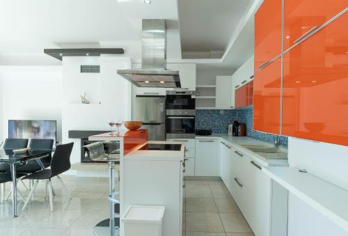 a kitchen with white cabinets and an orange at Oniro Luxury Villas in Toroni