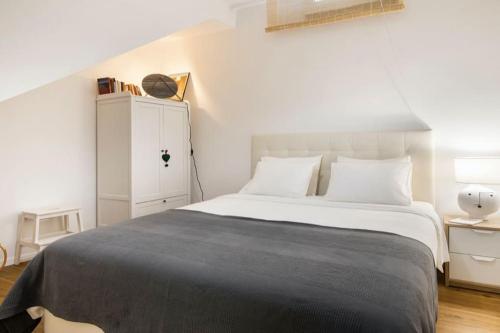 a bedroom with a large bed and a white cabinet at Lisbon Intendente Terrace Apartment with BBQ in Lisbon