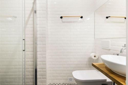 a white bathroom with a sink and a shower at Lisbon Intendente Terrace Apartment with BBQ in Lisbon
