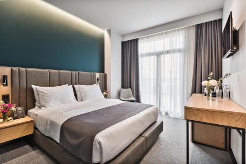 a hotel room with a large bed and a desk at Graf Hotel in Tbilisi City
