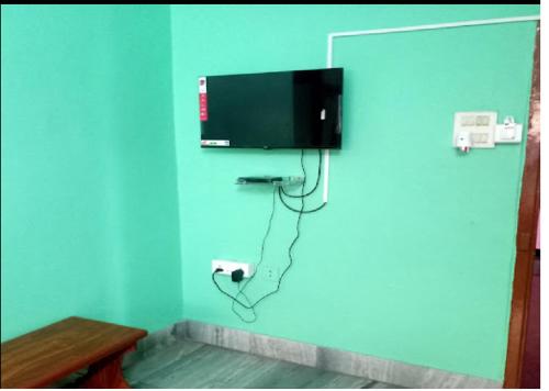 a room with a television on a blue wall at Nandita S Beach Bay Rest House By WB Inn in Visakhapatnam