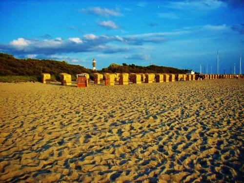 a sandy beach with a bridge in the background at Ostsee Hotel-Pension An der Lindenallee in Bad Doberan