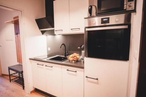 a kitchen with white cabinets and a sink and a microwave at Haus Österreich - Familie Digruber in Lackenhof