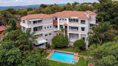 an aerial view of a large white house with a swimming pool at All Seasons Boutique Hotel in Pretoria
