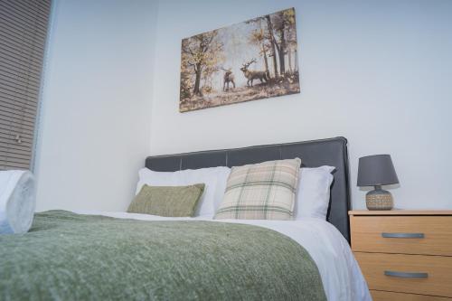 The Highfield Villa, 5 bedrooms, Northampton Centre, Sleeps 10 في Kingsthorpe: غرفة نوم بسرير مع صورة على الحائط