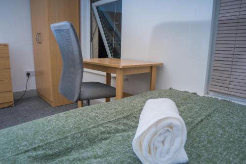 um quarto com uma secretária, uma cama e uma cadeira em The Highfield Villa, 5 bedrooms, Northampton Centre, Sleeps 10 em Kingsthorpe