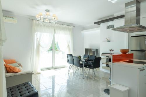 a kitchen and dining room with a table and chairs at Oniro Luxury Villas in Toroni