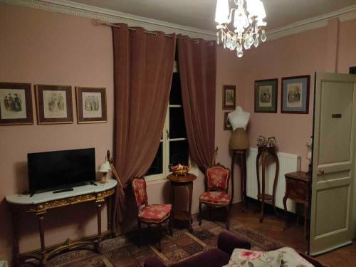 sala de estar con TV, mesa y sillas en Demeure en Seine - Gîtes et chambres d'hôte en bord de Seine, en Caudebec-en-Caux