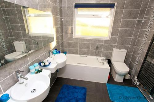 a bathroom with a sink and a tub and a toilet at CROYDE VILLA SUNSEA 6 Bedrooms in Croyde
