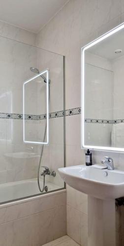a bathroom with a sink and a shower with a mirror at Ocean Pearl Apartment M in Funchal