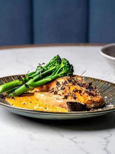 a plate of food with broccoli on a table at Radisson Collection Hotel, Warsaw in Warsaw