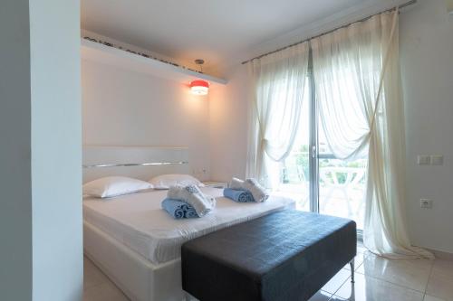 a bedroom with a bed and a large window at Oniro Luxury Villas in Toroni