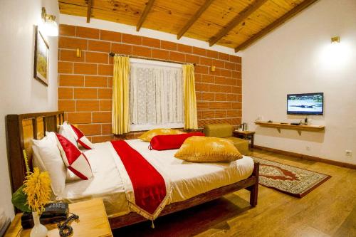 a bedroom with a bed and a brick wall at Altius Nest Hotel in Kodaikānāl