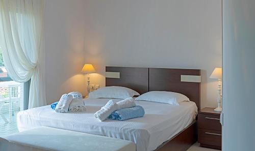 a bedroom with two beds with towels on them at Oniro Luxury Villas in Toroni
