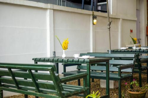 a green table and chairs with a vase on it at Altius Nest Hotel in Kodaikānāl
