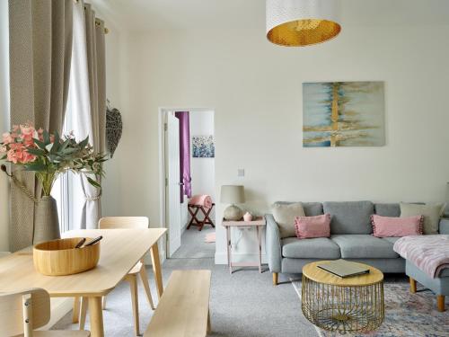 un soggiorno con divano e tavolo di Curb Properties - Super 2 Bed Apartment 5 Min From Town Centre a Cheltenham