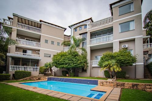 an apartment building with a swimming pool in front of it at All Seasons Boutique Hotel in Pretoria