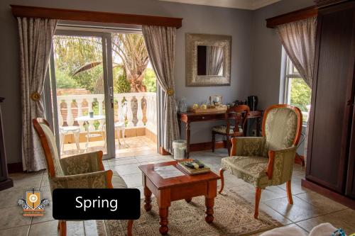 a living room with a table and chairs and a dining room at All Seasons Boutique Hotel in Pretoria