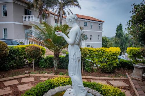 a statue of a woman standing in a garden at All Seasons Boutique Hotel in Pretoria