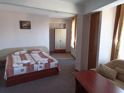 Petar Guest House في بانسكو: غرفة نوم بسرير واريكة وطاولة