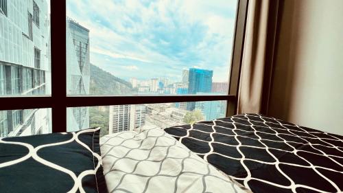 a bedroom with a view of a city from a window at Montana Suite 5, Empire Damansara in Petaling Jaya