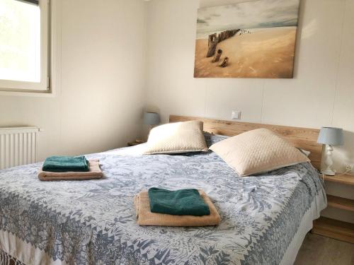 a bedroom with a bed with two towels on it at Chalet 538 op Recreatiepark De Wielen in Sint Maarten