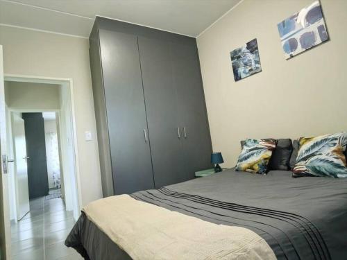 A bed or beds in a room at Modern 2 bedroom at Waterfall Ridge-Midrand