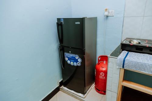 a black refrigerator in the corner of a kitchen at Kisanga Homestay in Moshi